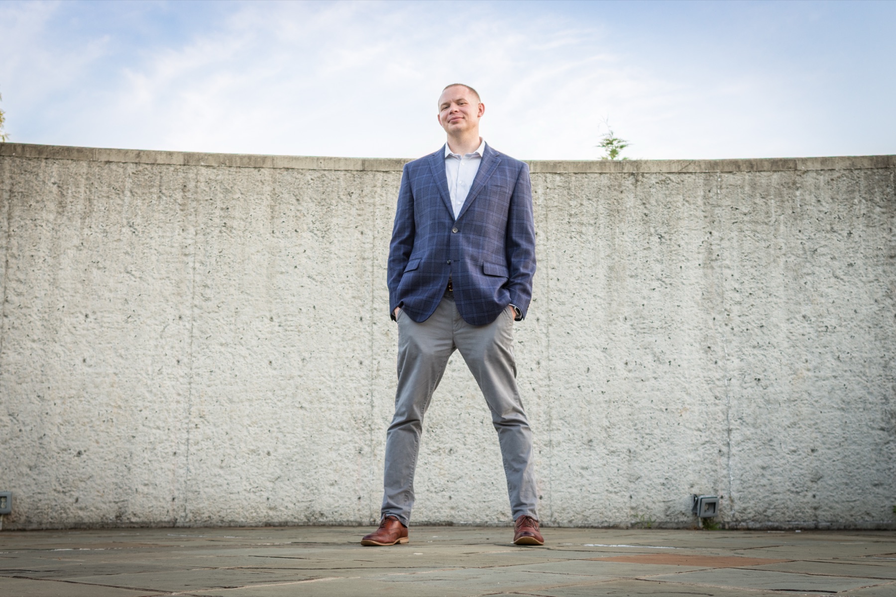 Man standing against a concrete wall under open sky
